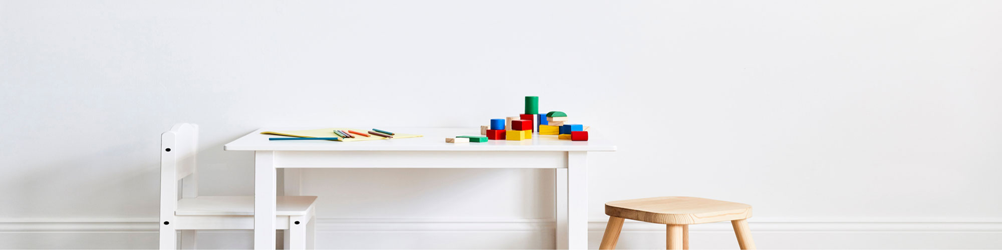 crayons and building blocks laid out on an empty table 